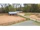Horse barn with stables and metal roofs set amidst a fenced, sandy paddock area at 3880 L Lawrence Trl, Graham, NC 27253