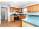 View of the kitchen featuring laminate floors, blue countertops and stainless steel appliances at 3880 L Lawrence Trl, Graham, NC 27253