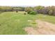 Expansive green field with scattered trees and natural landscape, perfect for outdoor activities at 3880 L Lawrence Trl, Graham, NC 27253