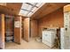 Rustic laundry room featuring wood paneling, skylight, and washer at 3880 L Lawrence Trl, Graham, NC 27253