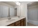 Double vanity featuring wood cabinets, light countertop, and large mirror at 3914 Glorybower Way, Apex, NC 27502