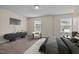 Relaxing bedroom showcasing a minimalist design with natural light and a TV at 3914 Glorybower Way, Apex, NC 27502