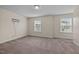 Neutral bedroom with 2 bright windows, neutral carpet, and mounted television at 3914 Glorybower Way, Apex, NC 27502