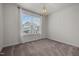 Sun-lit bedroom with a large window, plush carpeting, and an elegant chandelier at 3914 Glorybower Way, Apex, NC 27502