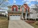 Charming two-story home featuring stone accents, a welcoming porch, and a well-manicured front yard at 3914 Glorybower Way, Apex, NC 27502