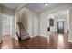 Bright foyer with hardwood floors and staircase, featuring views into multiple rooms at 3914 Glorybower Way, Apex, NC 27502