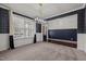 Open living space with dark hardwood floors, large windows, modern lighting, and designer wallpaper at 3914 Glorybower Way, Apex, NC 27502