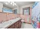 Bathroom with dual sinks, vintage pink tiling, and a seashell curtain at 4018 Moon Lindley Rd, Snow Camp, NC 27349