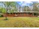 Traditional brick home featuring a well-kept lawn and mature trees adding curb appeal at 4018 Moon Lindley Rd, Snow Camp, NC 27349