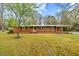 Charming brick home featuring a well-maintained lawn and mature trees at 4018 Moon Lindley Rd, Snow Camp, NC 27349
