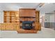 Cozy living area featuring a brick fireplace with shelving and cabinet storage at 4018 Moon Lindley Rd, Snow Camp, NC 27349