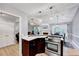 Open kitchen area with modern appliances, including a stainless steel oven, and a view into the living room at 413 Correy Pl, Clayton, NC 27520