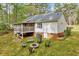 Exterior rear view of home with screened in porch, fire pit, and wooded background at 413 Correy Pl, Clayton, NC 27520