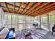 Relaxing screened porch with wood beam ceiling and seating area with colorful rug at 413 Correy Pl, Clayton, NC 27520