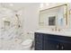 Elegant bathroom with a glass shower, blue vanity with gold hardware, and a gold-framed mirror at 4815 Oak Park Rd, Raleigh, NC 27612