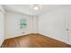 Empty bedroom boasts beautiful wood floors, a large window, and a spacious closet at 4815 Oak Park Rd, Raleigh, NC 27612