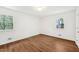 Bedroom with wood floors, white walls, and natural light from two windows at 4815 Oak Park Rd, Raleigh, NC 27612