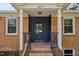 Inviting front entrance showcasing a brick facade, stylish front door, and manicured landscaping at 4815 Oak Park Rd, Raleigh, NC 27612