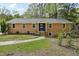 Charming brick home featuring a well-manicured front yard with a walkway to the front door at 4815 Oak Park Rd, Raleigh, NC 27612
