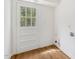Well-lit laundry room with wooden floors and a glass-paned door to the outside at 4815 Oak Park Rd, Raleigh, NC 27612