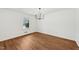 Inviting living room showcasing hardwood floors, a modern chandelier, and bright, neutral walls at 4815 Oak Park Rd, Raleigh, NC 27612