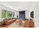 Staged living room showcasing a blue fireplace and a large window with natural lighting at 4815 Oak Park Rd, Raleigh, NC 27612