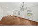 Spacious living room with gleaming hardwood floors, bright natural light, and modern chandelier at 4815 Oak Park Rd, Raleigh, NC 27612