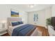 Nicely staged bedroom with wood floors, large window, ensuite bath, and a neutral color scheme at 4815 Oak Park Rd, Raleigh, NC 27612