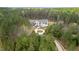 Aerial view of modern farmhouse, circular driveway, and wooded privacy in a park-like setting at 482 Emily Ln, Chapel Hill, NC 27516
