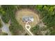 Aerial view of a white farmhouse with a circular driveway, surrounded by trees and green landscaping at 482 Emily Ln, Chapel Hill, NC 27516