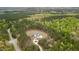 Aerial view showcases the modern farmhouse nestled amongst a dense grove of trees at 482 Emily Ln, Chapel Hill, NC 27516