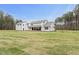 Sprawling backyard showcasing lush lawn, covered patio, and modern farmhouse architecture at 482 Emily Ln, Chapel Hill, NC 27516