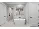 Bright bathroom featuring a modern standalone tub and a glimpse into the tiled shower at 482 Emily Ln, Chapel Hill, NC 27516