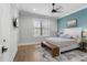 Well-lit bedroom featuring a ceiling fan, a large window, and hardwood floors at 482 Emily Ln, Chapel Hill, NC 27516