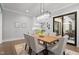 Dining room features a modern chandelier, wooden table, six chairs, and sliding glass door at 482 Emily Ln, Chapel Hill, NC 27516