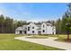 Stunning modern farmhouse with white siding, black trim, circular driveway and landscaped yard at 482 Emily Ln, Chapel Hill, NC 27516
