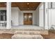 Inviting front porch with a brick stairs, wood ceiling, double doors, and white columns at 482 Emily Ln, Chapel Hill, NC 27516