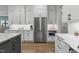 Modern kitchen with stainless steel refrigerator, white cabinets, and marble countertops at 482 Emily Ln, Chapel Hill, NC 27516