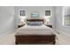 Bright main bedroom with neutral colors, dark wood furniture, and natural light from windows at 482 Emily Ln, Chapel Hill, NC 27516