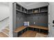 Hallway features built-in gray mudroom bench with storage and hooks alongside beautiful hardwood floors at 482 Emily Ln, Chapel Hill, NC 27516