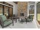 Covered patio with a brick fireplace, comfortable seating, and views of a private backyard at 482 Emily Ln, Chapel Hill, NC 27516