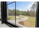 Window view of a winding driveway and wooded landscape, showcasing the property's privacy at 482 Emily Ln, Chapel Hill, NC 27516