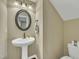 Bathroom with pedestal sink, round mirror, and standard toilet, exhibiting a clean and simple design at 520 Brier Crossings Loop, Durham, NC 27703