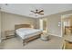 Spacious bedroom featuring a ceiling fan, a bed, and an ensuite bathroom with an entrance to the hallway at 520 Brier Crossings Loop, Durham, NC 27703