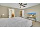 Bright bedroom with a ceiling fan, plush carpet, a mounted TV, and doors to a bathroom and hallway at 520 Brier Crossings Loop, Durham, NC 27703
