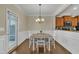 Bright dining room with wood floors, wainscoting, chandelier, and direct access to the kitchen and outdoor area at 520 Brier Crossings Loop, Durham, NC 27703