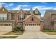 Inviting townhome showcasing brick accents, a two-car garage, and manicured landscaping under a clear blue sky at 520 Brier Crossings Loop, Durham, NC 27703
