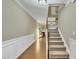 Bright hallway featuring hardwood floors, staircase, and view of fireplace and living area at 520 Brier Crossings Loop, Durham, NC 27703