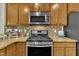 Kitchen featuring stainless steel appliances, granite countertops with backsplash, and wood cabinetry at 520 Brier Crossings Loop, Durham, NC 27703
