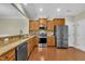 Modern kitchen with stainless steel appliances, wood cabinets, granite countertops, and hardwood flooring throughout at 520 Brier Crossings Loop, Durham, NC 27703